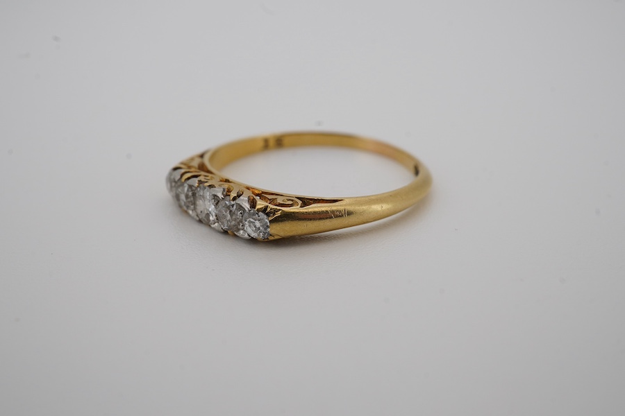 An early 20th century yellow metal and graduated five stone diamond set half hoop ring, size N, gross weight 2 grams. Condition - fair